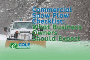Snow plow clearing a commercial parking lot during a storm